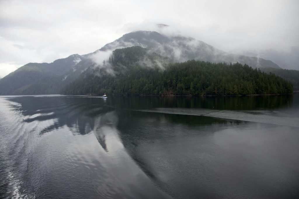 Waters around the great bear rainforest with one boat in the water on a misty day